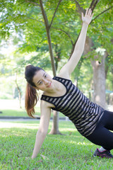 Portrait of thai adult beautiful girl doing yoga exercises in the park