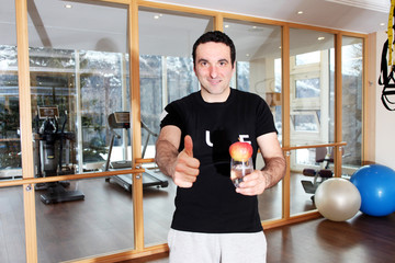 Fitnesstrainer mit Glas und Apfel