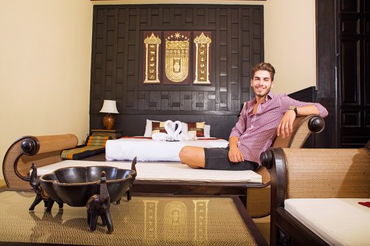 Young man relaxing in an Asian-styled hotel room 