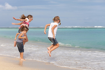 Three happy children  playing on the beach