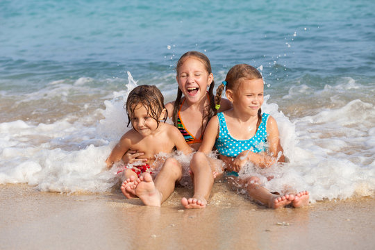 Three happy children  playing on the beach