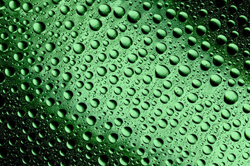 Green water drops on glass surface texture.