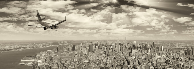 Black and white view of airplane over New York City. Tourism con