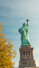 Fototapeta premium Statue of Liberty surrounded by autumn trees, New York City