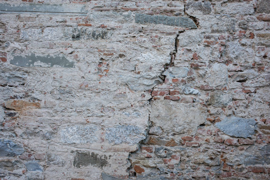 Muro di mattoni e crepa, trama texture sfondo