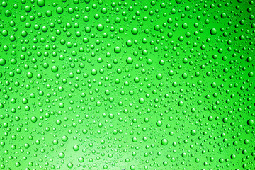 Green water drops on glass surface texture.