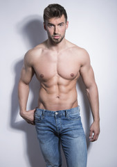 Fototapeta premium handsome young bodybuilder with toned body posing shirtless