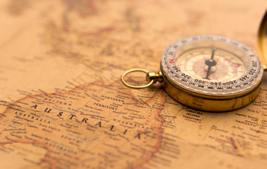 Old compass on vintage map selective focus on Australia