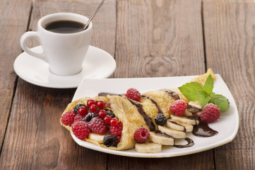 Cup of coffee and pancakes with berries
