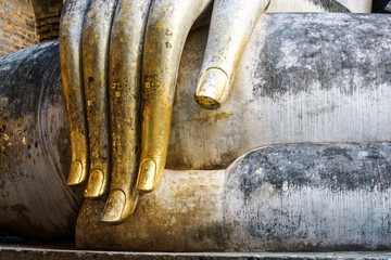 gold leaf offerings fingers wat si chums big buddha sukhothai 