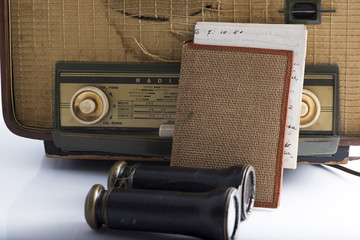 some vintage and antique objects including a radio, binoculars and an old letter