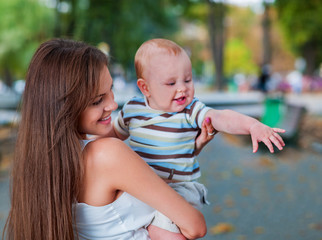 Happy loving mother and her baby outdoors.