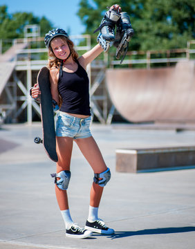 Teen girl sitting on his skateboard outdoor.
