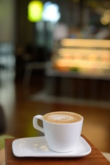 hot milk art coffee on wooden table in a cafe