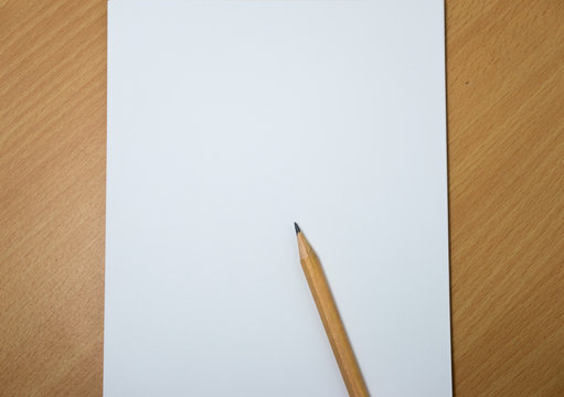 white paper and pencil on wooden background