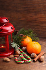 Christmas spirit: nuts, tangerines, Christmas tree, nuts, a flashlight on a dark wooden background