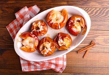baked apple with cinnamon and sugar on dark wooden background