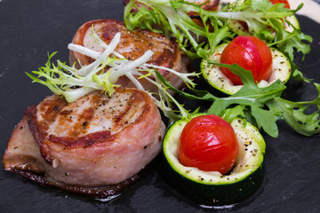 Grilled pork medallions with bacon, closeup