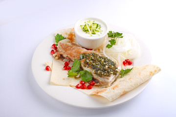 roasted meat with pita pomegranate and onion on a white plate