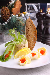 forshmak decorated with salad , lemon and red caviar bread