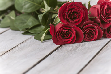 Red roses and a heart on wooden board, Valentines Day background, wedding day