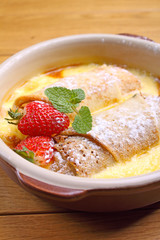 rolled pancakes on a plate with honey and powdered sugar