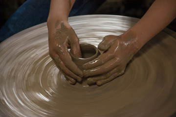 Hands working on pottery wheel 