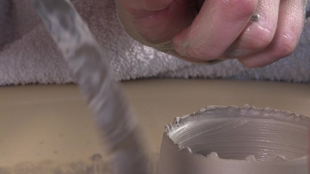 potter working with clay on a lathe