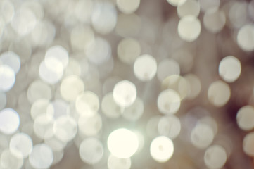 Light blurred background with white bokeh lights on it. Festive holiday theme with copyspace