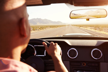 Man In Convertible Car Driving Along Open Road