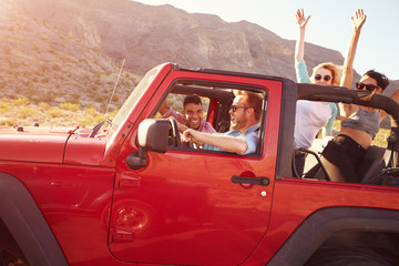 Friends On Road Trip Driving In Convertible Car