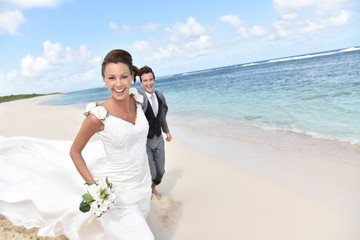 Just married couple running on a caribbean beach