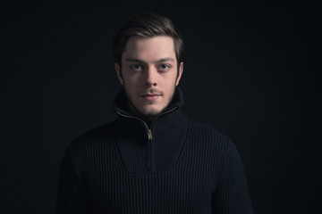 Obraz premium Man with stubbly beard wearing dark blue turtleneck.