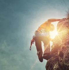 Foto op Canvas Man mountain climbing with a sunburst © XtravaganT