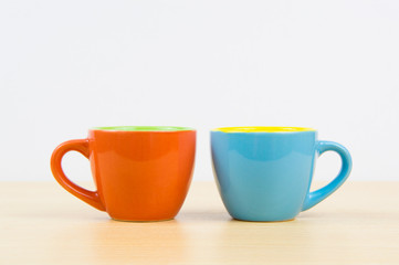 Colorful coffee cups on wood board closeup