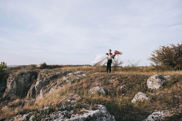 Obraz premium Young newly married couple chasing each other in field
