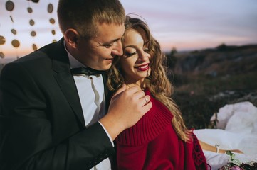 Silhouette of a young bride and groom on sunset background