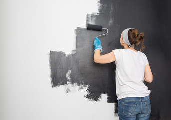 Woman paint wall at home.

