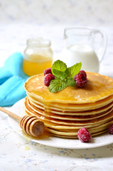 Homemade pancakes with honey and raspberry.
