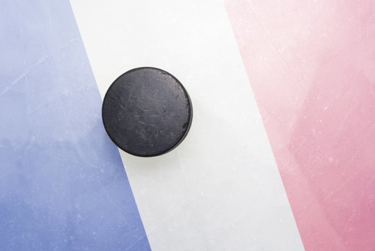 old hockey puck is on the ice with france flag