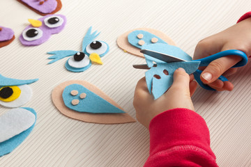 child cutting felt to make an owl craft