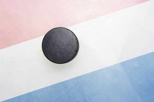 old hockey puck is on the ice with netherlands flag