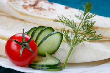 Fresh vegetables with a tortilla bread, close up, selective focus on the tomato