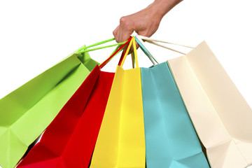 Hand holding colorful shopping bags - isolated