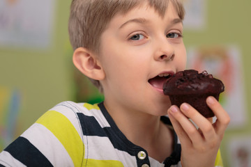 Boy eating caloric muffin