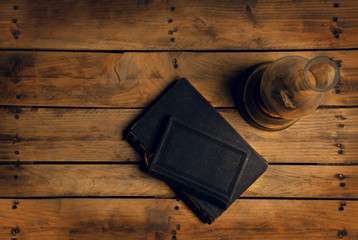 old book on a wooden table by kerosene lamp, candlelight