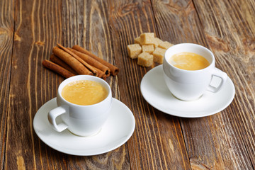 Two cup of hot espresso, cinnamon and sugar cane
