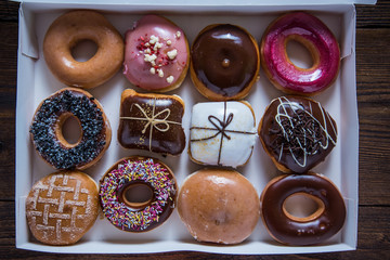 Dozen artisan donuts in box on table