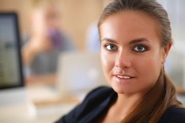 Young woman working in office, sitting at desk