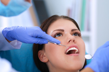 Woman dentist working at her patients teeth